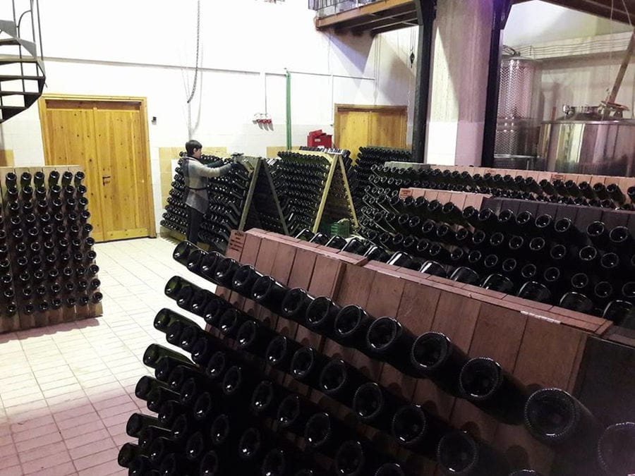 wine bottles on top of each other storaged on the ground in 'Domaine Karanika' cellar